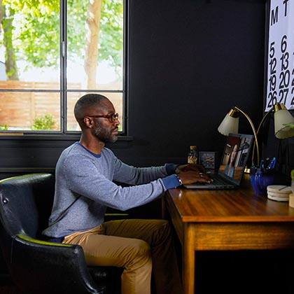  man in home office typing on laptop. 